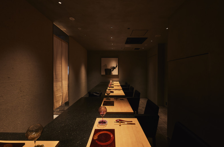 Shell-Infused Terrazzo Countertop. The kappo counter welcomes guests with its unique terrazzo tabletop, richly embedded with local shells, a subtle yet powerful nod to Hiroshima's coastal heritage. - Photographer Shinsui Ohara