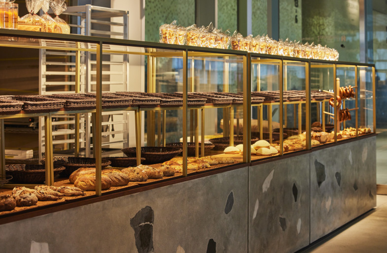 The Bakery Showcase. A detailed view of the bakery's showcase, highlighting the textured beauty of the river-stone inspired terrazzo. - Photographer Shinsui Ohara