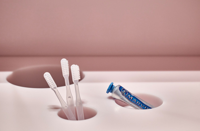 The sanitary area, completed with a built-in basin and toothbrush compartment where patients brush their teeth, is drenched in a sugary, cotton-candy pink. - Daniel Schäfer