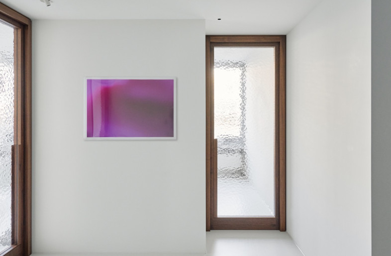 The monochromatic walls, floors and ceilings emphasize the medical use of the space while providing a bright canvas for the selected art pieces and furniture. - Daniel Schäfer