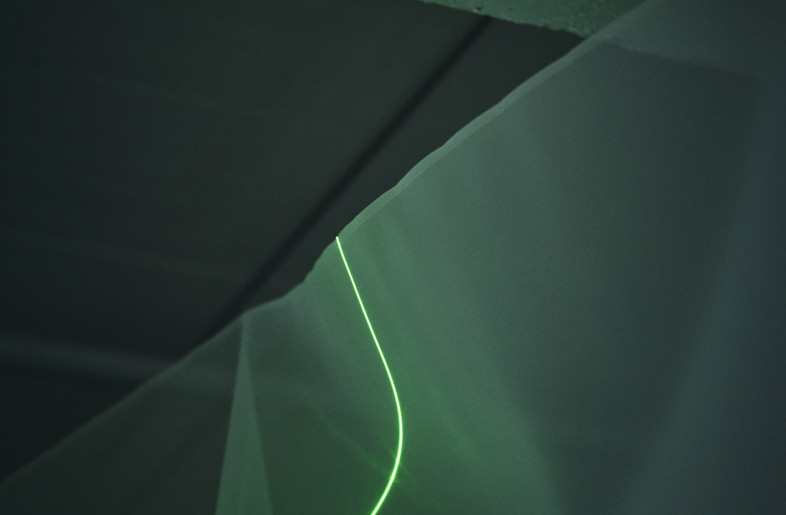 The green laser beam penetrates the textile and is also projected onto the entire space. Although the space is always the same, the light alone brings out a different expression of the space. - Masaki Ogawa