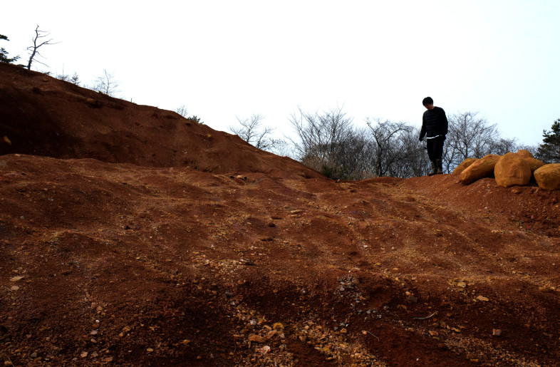 This mountain is covered with red soil. This is a sign of the history of the Daté Kan Stone itself as soil and is attributed to rust on the surface of the Daté Kan Stone. - TAKT PROJECT