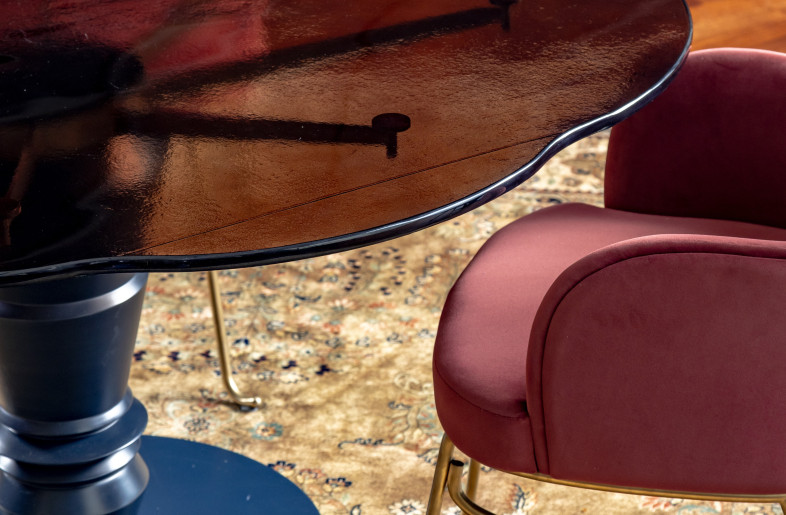 The dining tables are customised to feature a glass top resembling the rich hues of caramel, inspired by the candy floss makers of childhood, and a base modelled after the elegant turned timber Channapatna toys, shaped like a chess piece and painted blue. - Jeetin Sharma