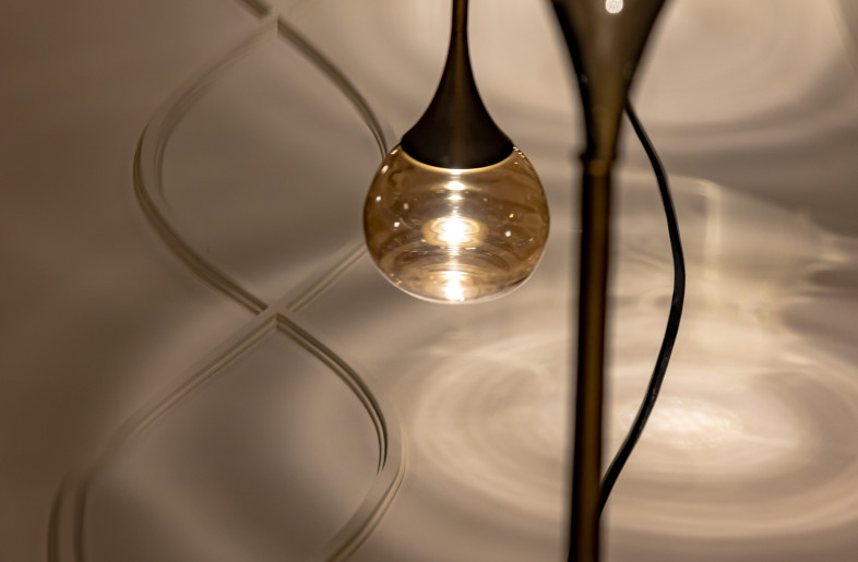 The pod-like light fixtures over the sculptural molten metal table cast ripples in a pool of light on the false ceiling, adding another layer to the dynamism of the interiors. - Jeetin Sharma