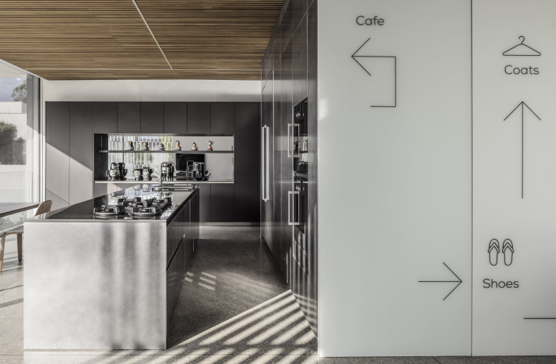 The cube contains essential domestic functions — a staircase, guest restroom, storage, utilities, and kitchen cabinetry. - Amit Geron