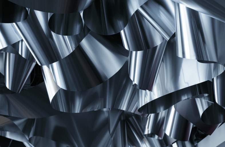 A single strip of aluminium is bent and twisted to fill the ceiling with textured waves throughout the entirety of the office. - Daisuke Shima