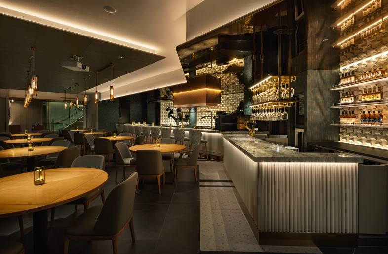 The ceiling’s glossy texture and the shapes of the architectural divisions appear as lines of light, giving the interior a distinctive character. - Nacasa & Partners