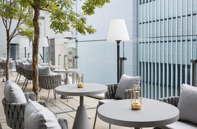 The daytime terrace overlooking Ginza offers a bright and comfortable atmosphere, where the greenery stands out beautifully. - Nacasa & Partners