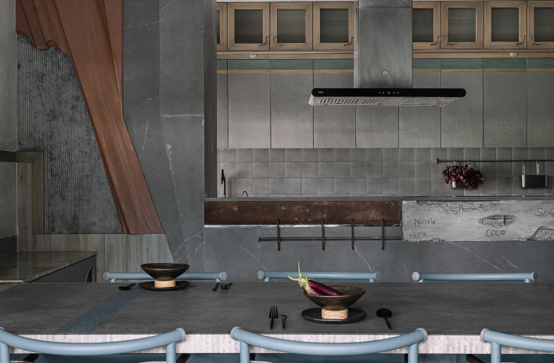 The functional core – entry, kitchen, dining – features burnished concrete floors that ground the space. - Ishita Sitwala