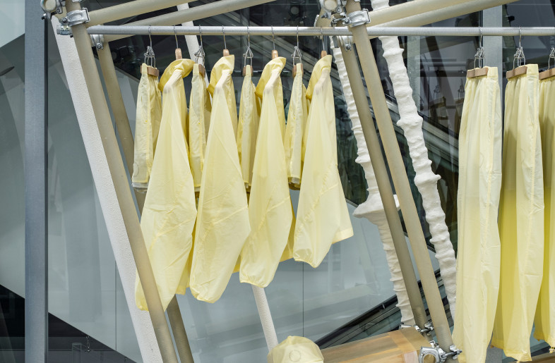 In SS25, handcrafted translucent FRP were used, allowing the wooden rafters under the shelf boards and the threaded post of the jack base to show through, creating visual harmony with the sheer apparel. - Kenta Hasegawa
