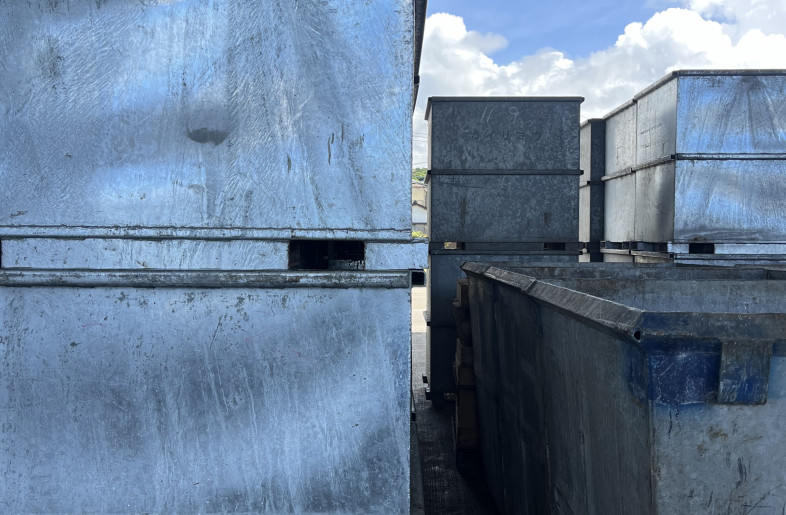 Stacks of metal fish boxes at the port, inspiring the project’s design language - atelier SALAD