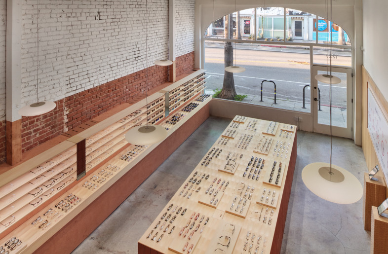 Looking down from the spiral staircase, the layered interplay of existing architecture and new interventions reflects the project’s adaptive reuse and spatial clarity, highlighted by the dual-tone finish that visually separates the upper and lower zones. - Daici Ano