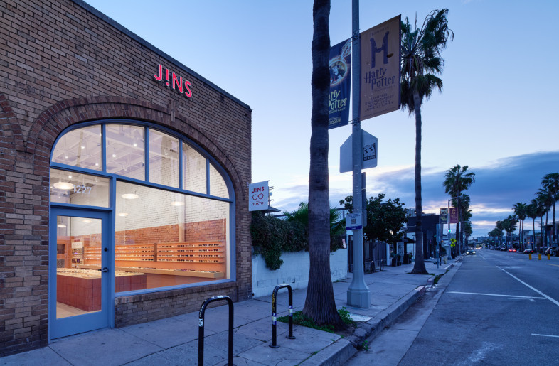 At dusk, the textured warmth of the Japanese-inspired interior glows through the arched façade, quietly harmonizing with the cool blues and palm-lined stretch of Abbott Kinney Boulevard. - Daici Ano