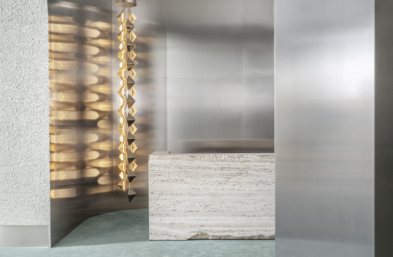 Welcome desk in hand-carved travertine, aluminium walls and ceiling lamp designed by Draga & Aurel for Visionnaire - Max Zambelli