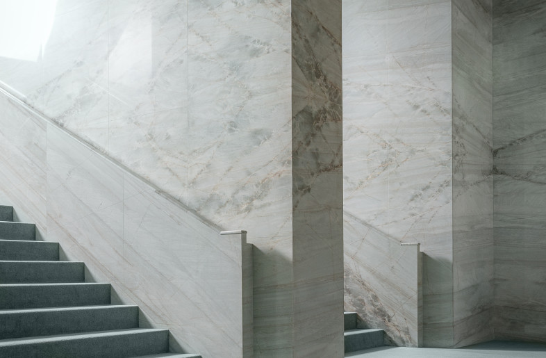 The grand double staircase that truly emphasizes the theme of descent, a metaphor for self-discovery that lies at the core of the new showroom concept.  Walls covered with emerald quarzite stone - Max Zambelli