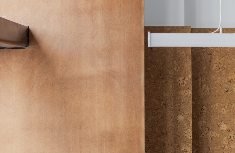 Cork panelling and natural-wood column ground the shop in a natural materiality. - Emmy Martens