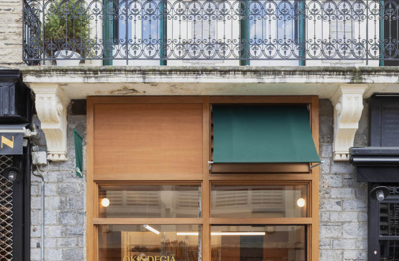 A retractable viridian awning brings the brand colours into the façade. - Emmy Martens