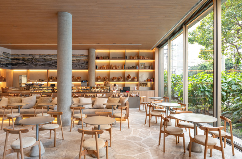 CHA CHA BOULANGERIE at PULSO HOTEL | Cha Cha brings together elements of café, boulangerie, rotisserie, and gourmet store. A notable feature is the mural by artist Carla Caffé, which wraps around the upper walls and showcases a graphic cartography of São Paulo’s neighborhoods. The venue connects visually to the lobby through a framed view of the fireplace, reinforcing the sense of continuity. - Fran Parente