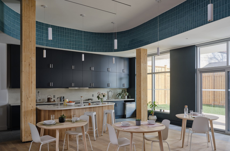 A a light-flooded shared kitchen and dining area overlook a private garden, connecting residents to nature.. - Doublespace