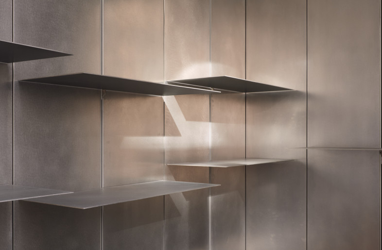 Height-adjustable metal shelves with concealed cupboards behind them. - Elias Hassos