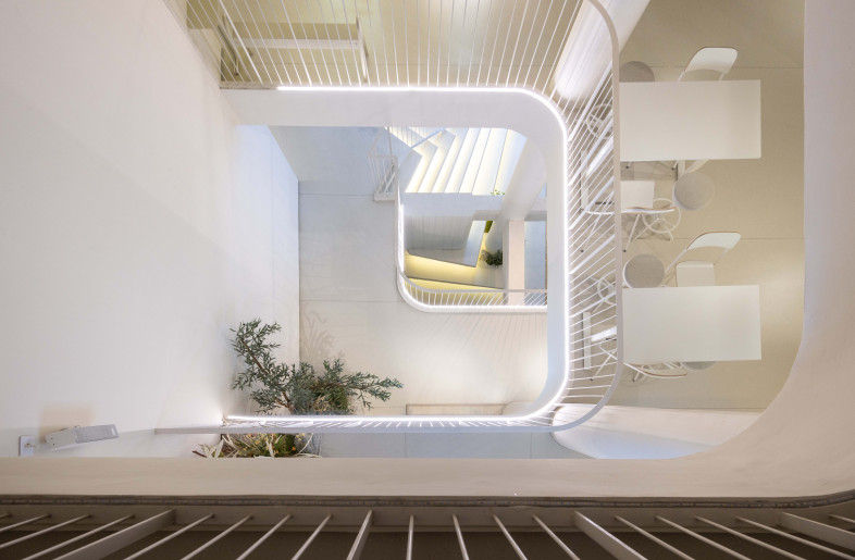 Skylights bring natural light from above. Openings are staggered with usable spaces, letting light reach deeper inside and allowing views of people using the space. This helps with low ceilings and creates visual connections across all floors. - Rungkit Charoenwat