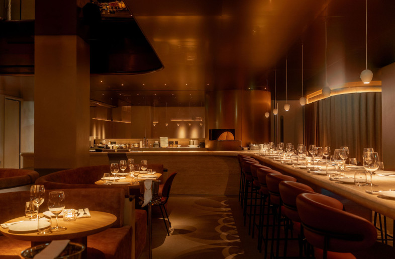 The communal table extends toward the show kitchen, uniting chef and guests in a shared experience. - STEVIE CAMPBELL CREATIVE