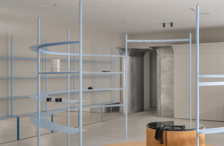 At the heart of the 60-sq-m space rests a powder-blue, ring-shaped shelving unit. More than a place to stock toys and accessories, the circular structure serves as a visual anchor and a gathering point. - Yevhenii Avramenko