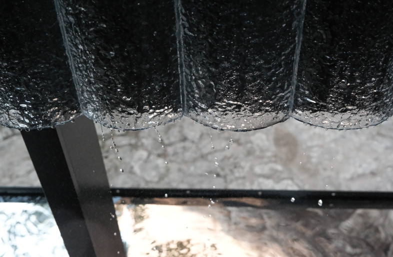 Water runs along glass tiles on the interior of the space, dripping into the pools at the base. - Aptdotapt