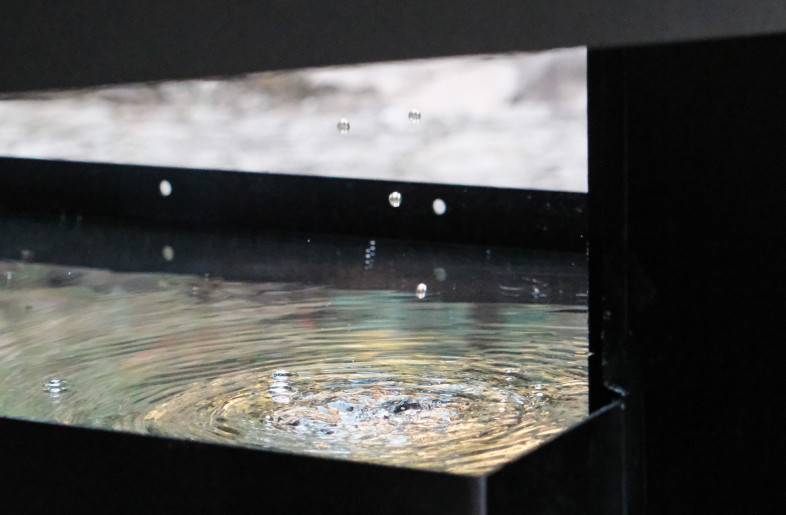 Drops of rain fall into two reflective pools at the base of the pavilion. - Aptdotapt