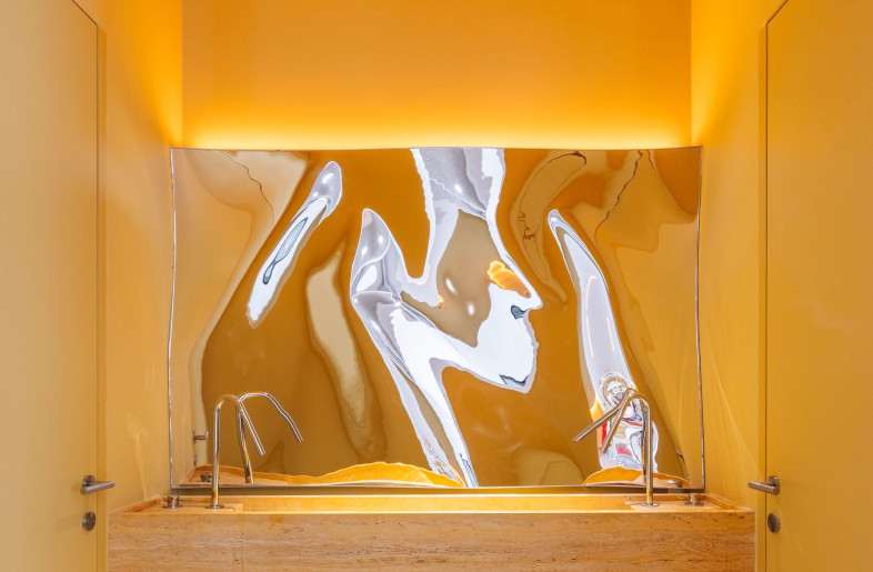 A bespoke, hand-bent mirror in the washroom brings a spark of novelty. - Francisco Nogueira