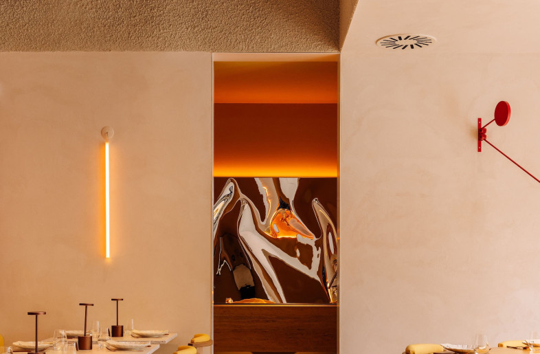 A view of the washroom from the dining space gives a sneak peek of the sculptural mirror. - Francisco Nogueira