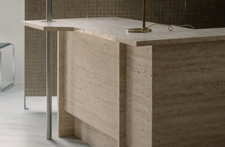 A travertine check-out counter and a handful of brightly coloured stools add tonal and material diversity. - Wen Studio
