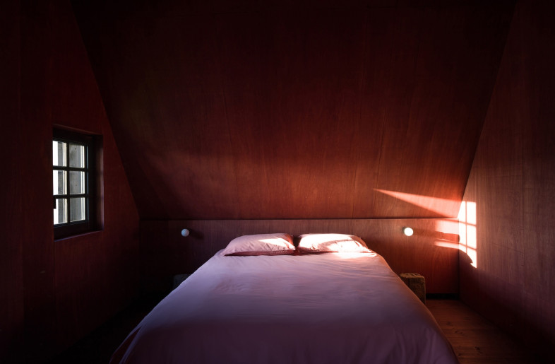 Carefully placed windows draw in light and frame views of the surrounding fields, while a warm palette of reds, browns and greens reflects the tones of the original structure. - Crispijn van Sas