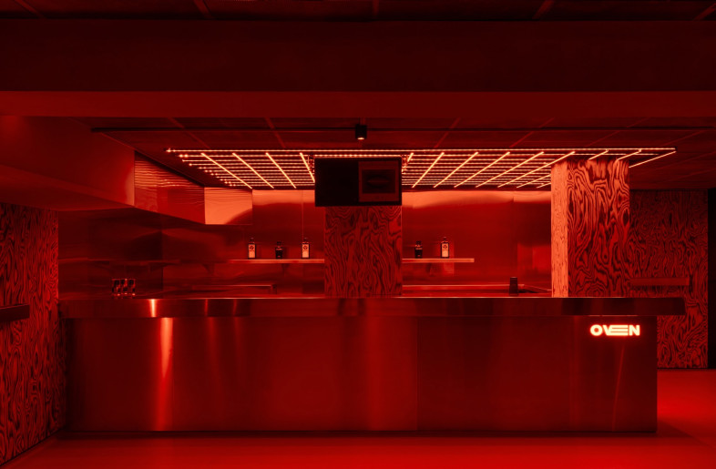 Two bars are located on either side of the central DJ booth, illuminated by LED grids reminiscent of heating elements. - Simone Marcoli