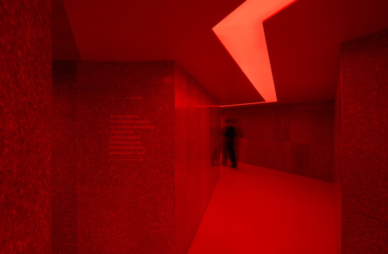 Bold, ambient lighting bathes sections of the space in reds, blues and purples. - Ernest Theofilus
