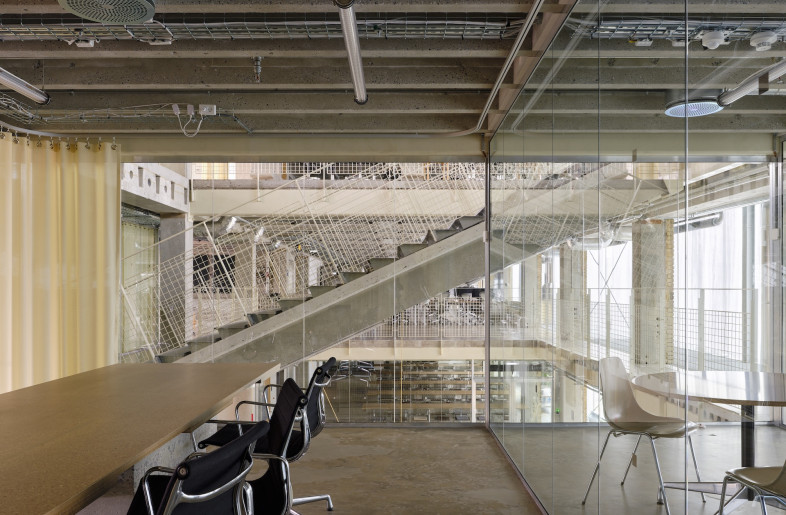 A palimpsest of contrasts, brick floors stop abruptly, pipes and ventilation systems remain exposed while soft touches like lemon-yellow curtains and scattered cushions humanize the otherwise industrial space. - Hampus Berndtson