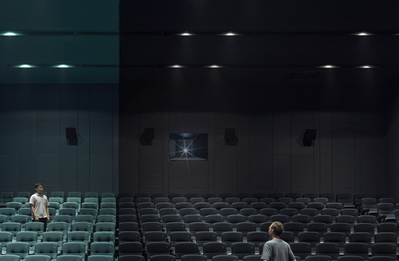 Walking into the auditorium with giant screen, the contrast between red and cyan gives a more shocking visual effect. - Jonathan Leijonhufvud Architectural Photography