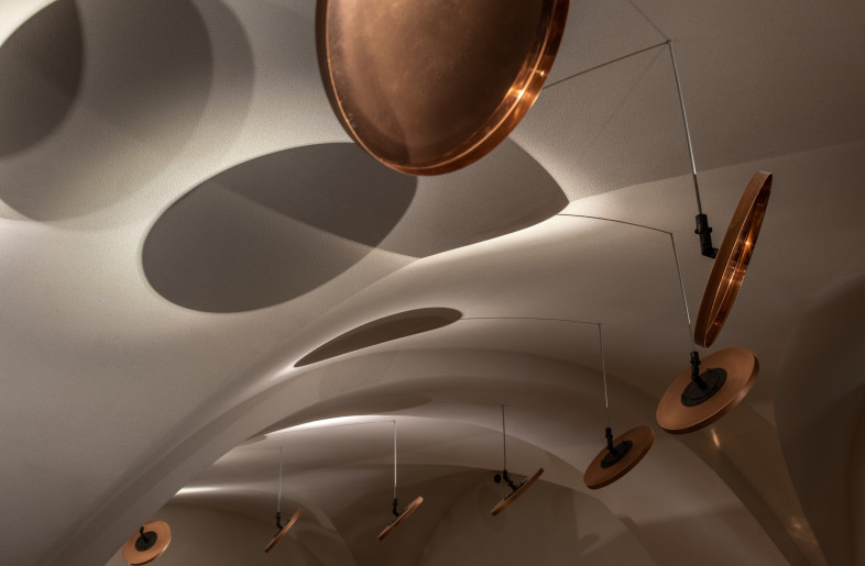 Copper plates hung under the ceiling reflect spotlight rays to the tables. - Andriy Bezuglov