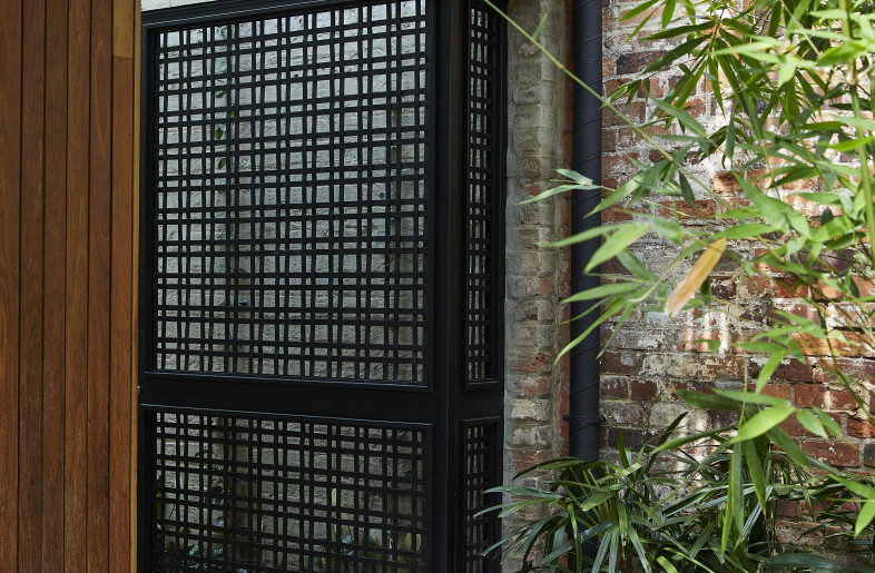 The original brick boundary wall is left exposed. A relic, providing texture, now partially covered in climbing plants. - Derek Swalwell