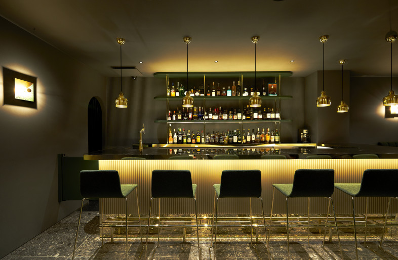 Due to the effects of the golden-hued mirrored baseboard and indirect lighting, the bar seems to float in its surroundings. - Masanori Kaneshita