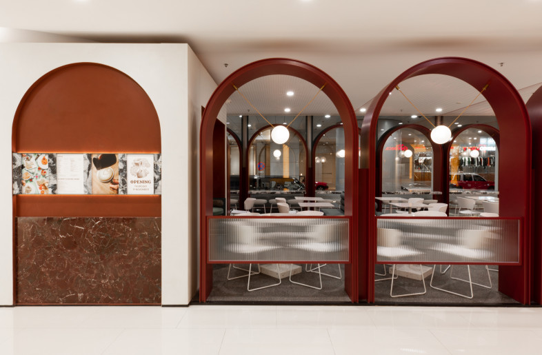 Arches border a designated open space within the mall to provide shelter and privacy to patrons and to strongly define the café space within the otherwise bland area. Parallel arches are linked by subtle lines of red elastic forming a semi-solid ceiling of repeating barrel vaults. - Metagram
