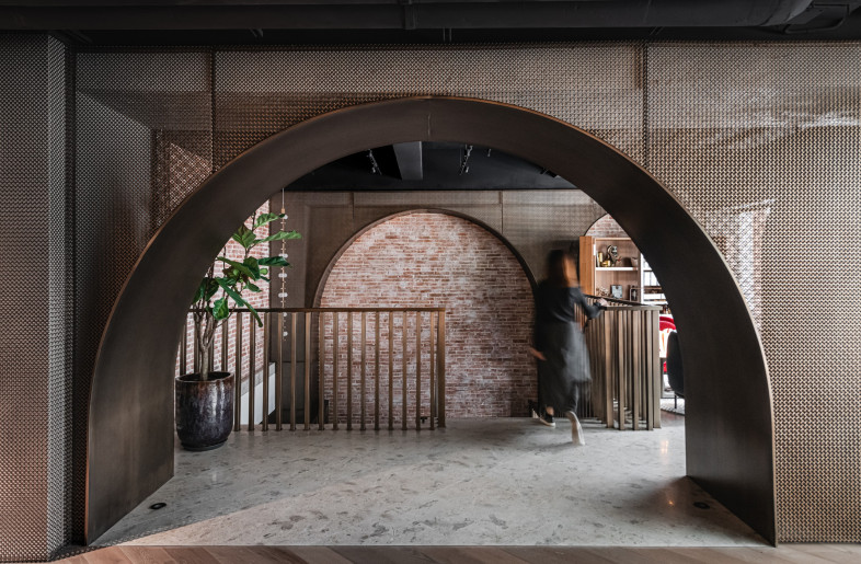 Bronze mesh arches mark the arrival to the upper floor 'residence', injecting a sense of warmth curiosity. - Photograph by Kevin Mak