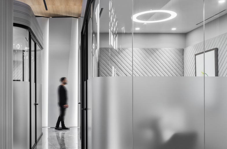 To insure the feeling of privacy in the small meeting rooms located in the area with high ceilings they were designed as a box-in-box solution. The opaque film on the glazing lets the natural light in, but keeps the privacy of the people inside.. - Photo by Ibrahim Ozbunar https://www.ibrahimozbunar.com/