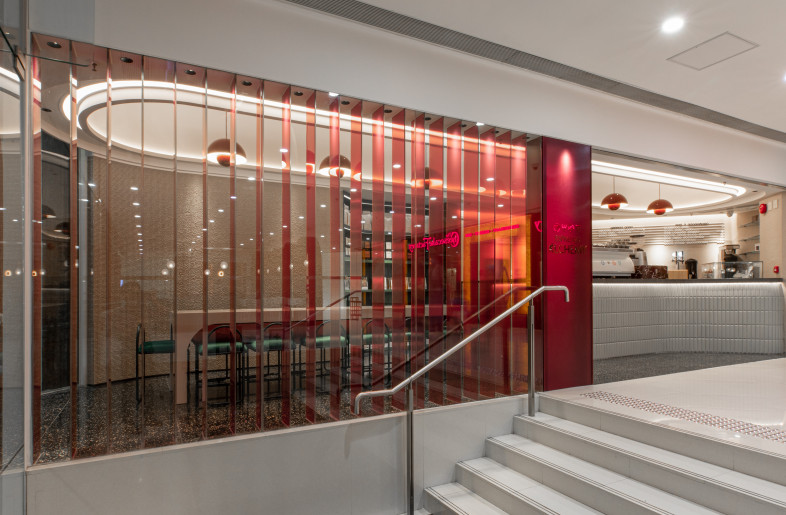 A wide and open shop front faces the mall. In order to create privacy for patrons inside the design featured a layer of red glass fins across the shopfront glass that disappears in elevation but becomes solid at sheer views. The entire barrel vault is visible externally, and immediately draws attention up toward the ceiling. - Metagram