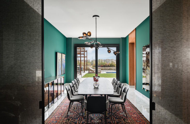 Jungle green walls complimented by an oriental rug and marvelous Bocci chandelier. - Nour El Refai (Photography)