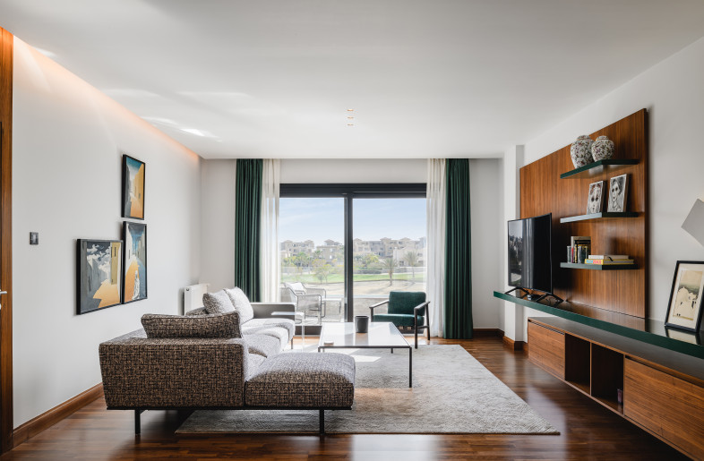 A comfortable family living room accented with the deep green and blue color scheme. - Nour El Refai (Photography)