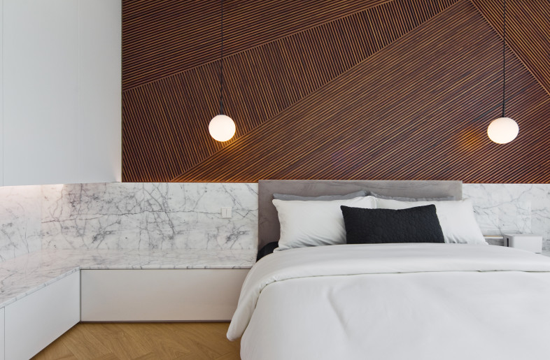 The designer formed a warm space for the guest bedroom with striped wood panel and the wood floor. - N/A