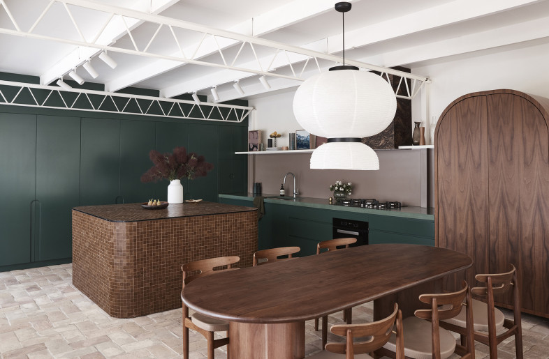 Rich golden brown hues and the deep forest green cabinetry complement the site’s natural bushland of flora and fauna creating a unified space from the inside out. - Photography: Damian Bennett