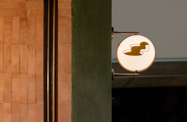 The icon's endearing face and gracefully flowing hair on our bespoke lighting signage, subtly complementing the logotype that’s on the other side. - Photographer: Amanda Kho