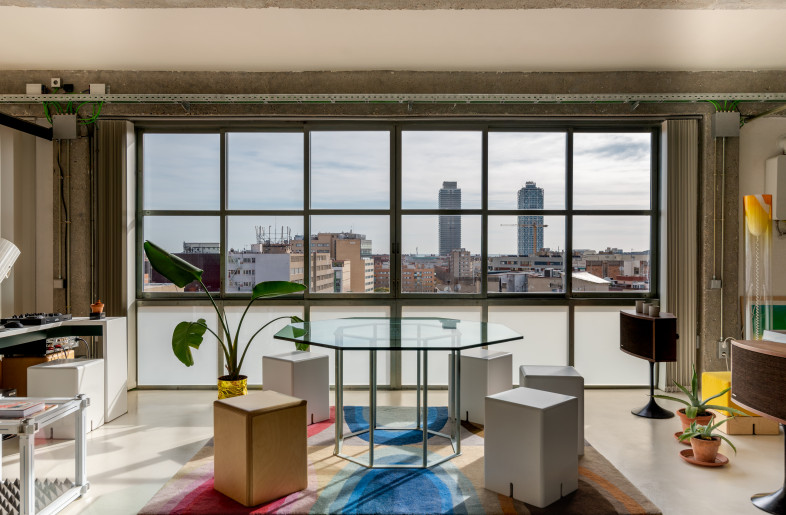 Octagonal Glass Table and Stools by KEIGIO. Fully Openable Windows with LCD Glasses and Poble Nou District's View. - Photographer: Adina Ilie